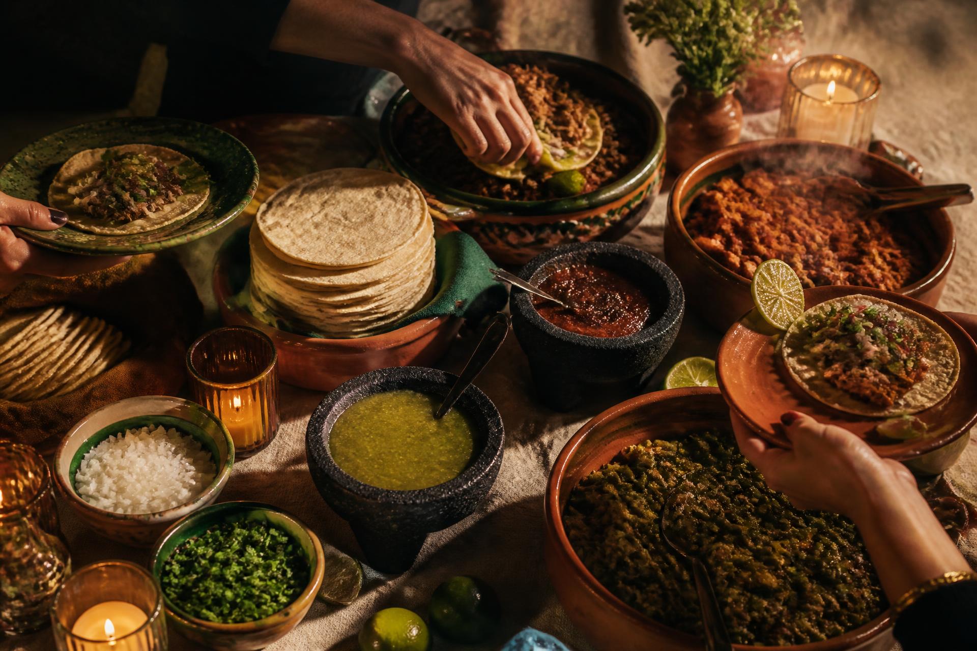 Taquiza mexicana abundante con tortillas recién hechas, guisados y salsas